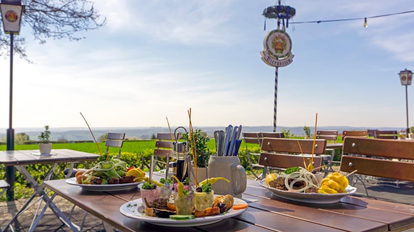 Gedeckter Tisch mit griechischen Spezialitäten im Paulaner Biergarten des Restaurant Zeus mit Panoramablick über Esslingen